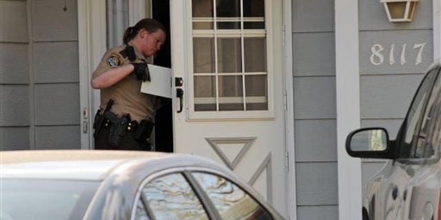 April 9: A police officer investigates the scene where three people were shot and killed at an in-home day care in Brooklyn Park, Minn.