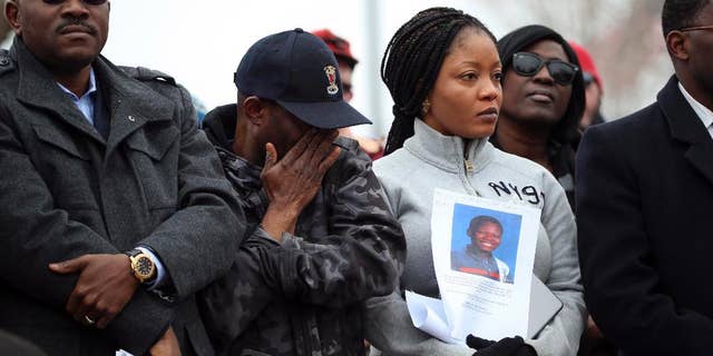 FILE- In this March 23, 2015, file photo, Barway Collins' father, Pierre Collins, wipes away tears as he stands with his wife, Yamah, and supporters at vigil in Crystal, Minn. for their missing son. A body found in the Mississippi River over the weekend has been identified as that of the 10-year-old Minnesota boy, Barway Collins, who has been missing for nearly a month, the police said Sunday, April 12, 2015. (AP Photo/The Star Tribune, Jeff Wheeler, File)