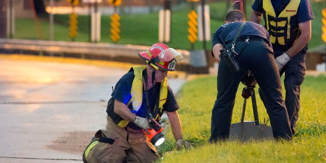 June 30, 2014: In this photo Cedar Rapids firefighters open a storm sewer cover as they search for a teenager who was swept away in a storm drain after heavy rainfall overwhelmed the eastern Iowa city's storm sewer system.
