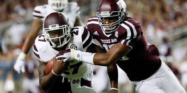 Oct 3, 2015; College Station, TX, USA; Mississippi State Bulldogs running back Aeris Williams (27) carries the ball as Texas A&M Aggies defensive lineman Myles Garrett (right) defends during the second half at Kyle Field. Texas A&M won 30-17. Mandatory Credit: Soobum Im-USA TODAY Sports