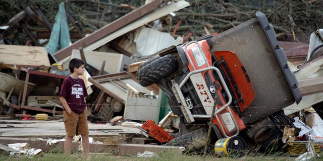 April 27: A young resident surveys the damage to a home near Bond, Miss.