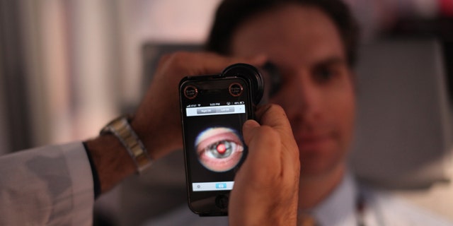 This image provided by TEDMED, shows a medical student preparing to photograph the inside of someone&amp;#39;s eye using a special tool that taps a smartphoneâs camera during a recent TEDMED conference in Washington. Companies are developing a variety of miniature medical tools that hook onto smartphones to provide almost a complete physical. The hope is that this mobile medicine will help doctors care for patients in new ways, and also help people better monitor their own health. (AP Photo/TEDMED)