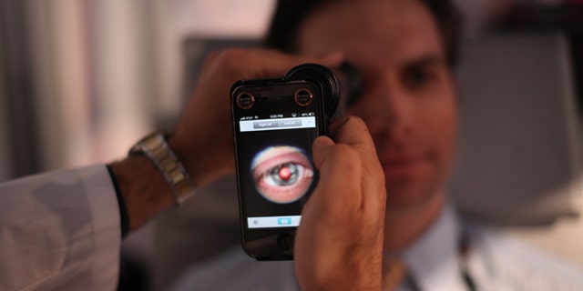 This image provided by TEDMED, shows a medical student preparing to photograph the inside of someone&amp;#39;s eye using a special tool that taps a smartphoneâs camera during a recent TEDMED conference in Washington. Companies are developing a variety of miniature medical tools that hook onto smartphones to provide almost a complete physical. The hope is that this mobile medicine will help doctors care for patients in new ways, and also help people better monitor their own health. (AP Photo/TEDMED)