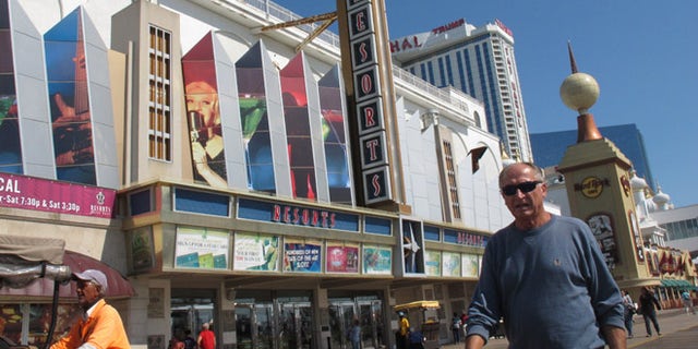 Pedestrians walk in front of Resorts Casino Hotel on Friday, Sept. 14, 2012, in Atlantic City, N.J. New Jersey casino regulators announced Friday they would allow the Mohegan Indian tribe of Connecticut to run the day-to-day affairs of Resorts. The Mohegan Indian tribe plans to oversee a $35 million expansion of Resorts that will include a Jimmy Buffett-themed Margaritaville complex. (AP Photo/Wayne Parry)
