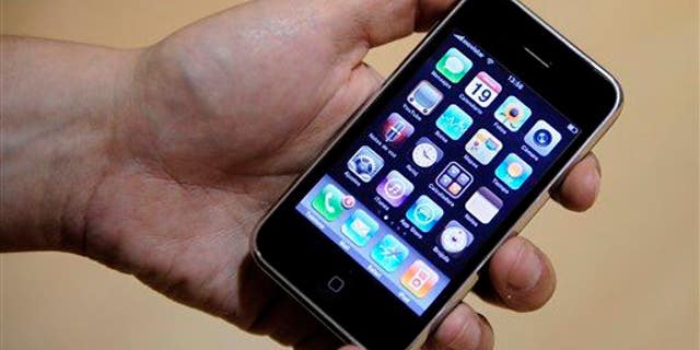 FILE - In this June 19, 2009 file photo, a shop worker holds the new Apple iPhone 3GS in Barcelona, Spain. Apple Inc. sold more than a million units of its latest iPhone model in the first three days, making it the most successful model yet. (AP Photo/Manu Fernandez, file)