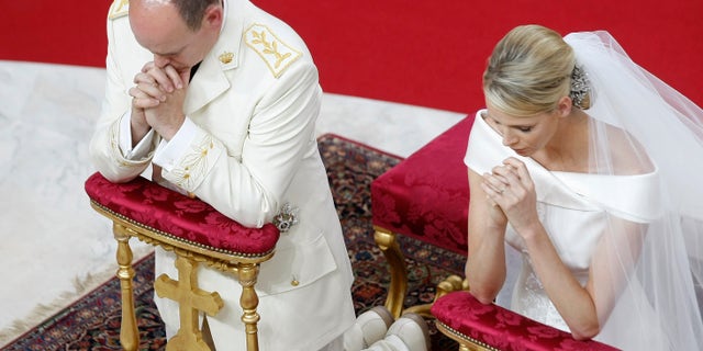 Prince Albert II of Monaco and Charlene Princess of Monaco kneel in prayer during their religious wedding ceremony at the Monaco palace, Saturday, July 2, 2011.