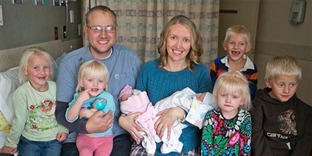 Tiffany and Chris Goodwin of Three Forks, Mont., pose with their children, including 3 sets of twins.