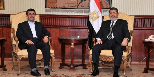Feb. 5, 2013: Iran's President Mahmoud Ahmadinejad, left, and Egyptian President Mohammed Morsi, right, pose for photographers in Cairo, Egypt.