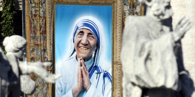 VATICAN CITY - OCTOBER 19: A tapestry depicting Mother Teresa framed by statues in St. Peter's Colonnade during the beatification ceremony led by Pope John Paul II on October 19, 2003 in Vatican City, Italy. Mother Teresa won the Nobel Peace Prize in 1979 for all of her charitable work. She died in 1997. (Photo by Franco Origlia / Getty Images)