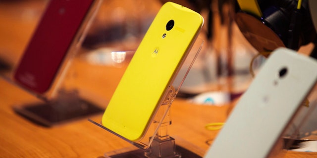 Different colored examples of Motorola's new Moto X phones rest on a table at a launch event in New York, August 1, 2013. REUTERS/Lucas Jackson (UNITED STATES - Tags: SCIENCE TECHNOLOGY BUSINESS TELECOMS) - RTX127J2