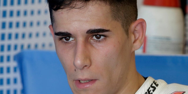 FILE, In this Friday, April 11, 2014 file photo, Luis Salom of Spain talks with team members in the garage area at the Circuit of Americas track during open practice for the Grand Prix of the Americas MotoGP motorcycle race in Austin, Texas. (AP Photo/Tony Gutierrez, File)