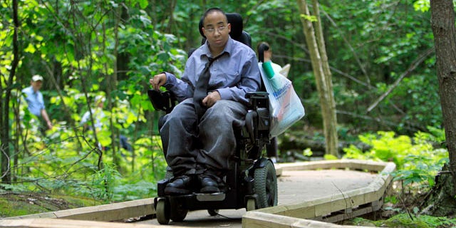 In this Thursday, June 16, 2011, photo, Chelsea Fernandez steers her wheelchair through the woods at the Crotched Mountain Rehabilitation Center in Greenfield, N.H. The center offers over 2.5 miles of privately funded trails designed to be easily accessible for people in wheelchairs and those who have difficulty walking. (AP Photo/Jim Cole)