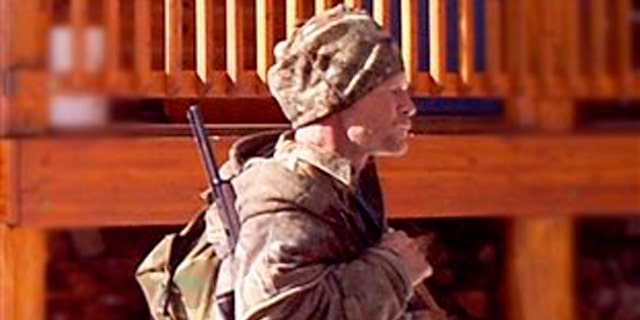 In this undated photo provided by the Iron County Sheriff's Office in January, a man is seen walking past a cabin in the remote southern Utah wildness near Zion National Park. Authorities believe the man in the photo, captured by a motion-triggered surveillance camera sometime in December, is a suspect responsible for more than two dozen cabin burglaries over the past five years.