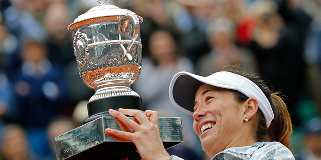 Spain's Garbine Muguruza holds the trophy after winning the final of the French Open tennis tournament against Serena Williams of the U.S. in two sets 7-5, 6-4, at the Roland Garros stadium in Paris, France, Saturday, June 4, 2016. (AP Photo/Alastair Grant)