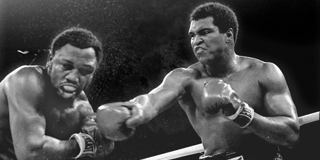 FILE-- Spray flies from the head of challenger Joe Frazier as heavyweight champion Muhammad Ali connects with a right in the ninth round of their title fight in Manila, Philippines, in this Oct. 1, 1975 file photo. Ali won the fight on a decision to retain the title. (AP Photo/Mitsunori Chigita)
