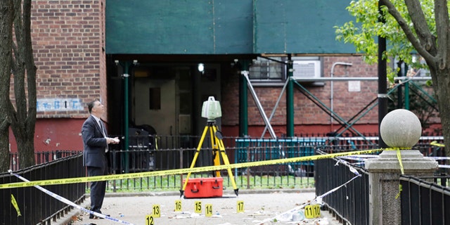 A New York City crime scene investigator inspects the scene of a triple homicide in Brooklyn.