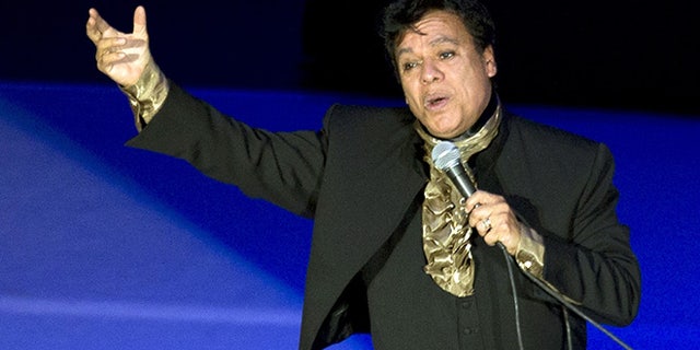 FILE - In this April 10, 2015 file photo, Mexican singer-songwriter, Juan Gabriel, performs at the National Auditorium in Mexico City. Gabriel won the first Latin Grammy Award of his long career Thursday, Nov. 17, 2016, but presenter Andres Ceballos of the group Dvicio apparently didn't realize it was a posthumous prize. "He's not here," Ceballos said. "The academy will make sure he receives this award." (AP Photo/Rebecca Blackwell, File)