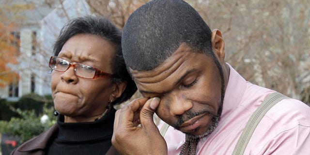 Nov. 23: Anthony Tisdale, right, father of Delvonte Tisdale, wipes his face during a news conference in front of his home in Charlotte, N.C. Investigators say they are now looking into the possibility that the Charlotte teenager, whose mutilated body was found on a suburban Boson street, may have fallen from a plane.