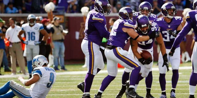 Sunday, Sept. 20: Minnesota Vikings defensive end Justin Trattou celebrates his interception as Detroit Lions quarterback Matthew Stafford sits on the field in the second half in Minneapolis. The Vikings won 26-16.