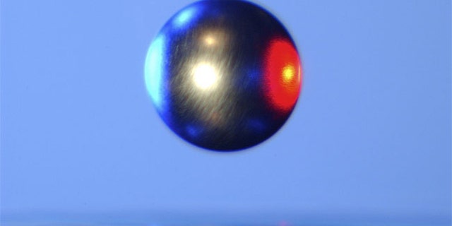 Inside a NASA Electrostatic Levitator, a ball of metal is suspended in mid-air by static electricity.