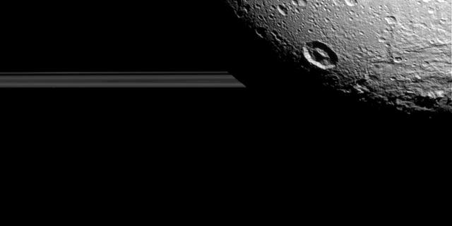 Saturn's moon Dione hangs in front of Saturn's rings in this view taken by NASA's Cassini spacecraft during the inbound leg of its last close flyby of the icy moon.