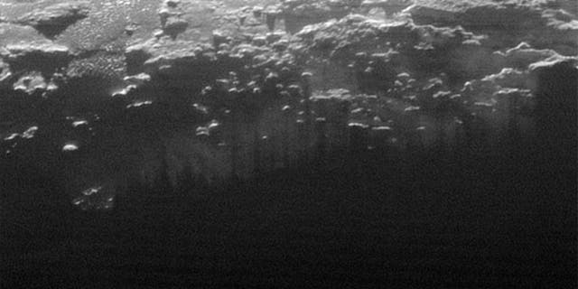 The setting sun illuminates a fog or near-surface haze, which is cut by the parallel shadows of many local hills and small mountains. The image was taken from a distance of 11,000 miles, and the width of the image is 115 miles.