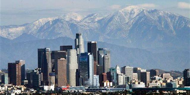 The snow-capped San Gabriel Mountains provide a backdrop to the downtown Los Angeles skyline as seen from Kenneth Hahn State Recreation Area in Baldwin Hills, Wednesday, Dec. 31, 2014.