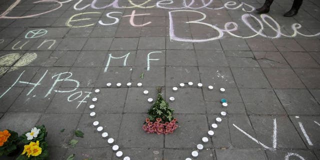 A message written on the ground reads "Brussels is beautiful" next to flowers and candles following attacks in Brussels on March 22, 2016. Airlines cancelled hundreds of flights and European railways froze links with Brussels after a series of bomb blasts killed around 35 people in the city's airport and a metro train, sparking a broad security response. AFP PHOTO / KENZO TRIBOUILLARD / AFP / KENZO TRIBOUILLARD (Photo credit should read KENZO TRIBOUILLARD/AFP/Getty Images)
