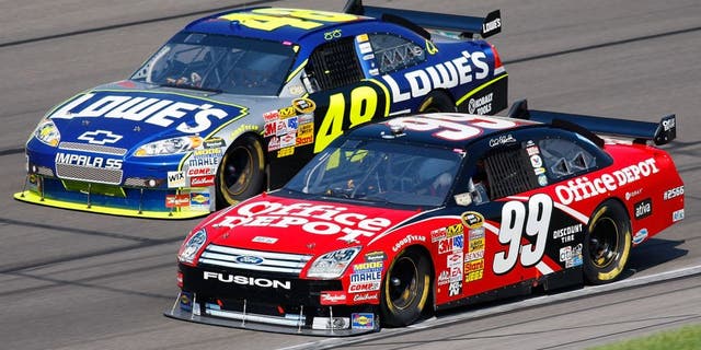 KANSAS CITY, KS - SEPTEMBER 28: Carl Edwards, driver of the #99 Office Depot Ford, and Jimmie Johnson, driver of the #48 Lowe's Chevrolet, drive during the NASCAR Sprint Cup Series Camping World RV 400 at Kansas Speedway on September 28, 2008 in Kansas City, Kansas. (Photo by John Harrelson/Getty Images for NASCAR)