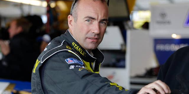 Driver Marcos Ambrose, of Australia, looks toward the outside from his garage during final practice for the NASCAR Sprint Cup Series auto race at Chicagoland Speedway in Joliet, Ill., Saturday, Sept. 13, 2014. Ambrose will leave NASCAR at the end of the season and return to his native Australia (AP Photo/Nam Y. Huh)