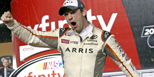 Daniel Suarez celebrates after wining the NASCAR Xfinity auto race and season title, Saturday, Nov. 19, 2016, in Homestead, Fla. (AP Photo/Terry Renna)