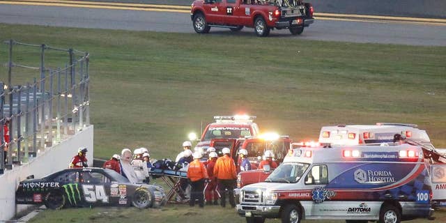 FILE - In this Feb. 21, 2015, file photo, Kyle Busch, center, is taken to an ambulance on a stretcher after he was involved in a multi-car crash during the Xfinity series auto race at Daytona International Speedway in Daytona Beach, Fla. He knew it was going to be bad when his car slid through the grass into the wall, and he knew immediately that both his leg and foot were broken. (AP Photo/John Raoux, File)