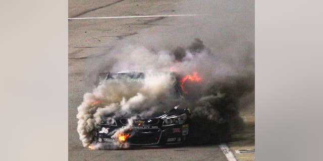 Reed Sorenson's car burns on pit row during the NASCAR Sprint Cup auto race at Richmond International Raceway in Richmond, Va., Saturday April 26, 2014. (AP Photo/Richmond Times-Dispatch, Dan Currier)