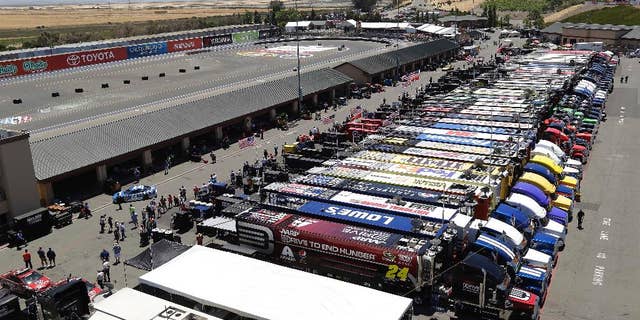 Jeff Gordon, left, pulls his car into the garage during practice for the NASCAR Sprint Cup Series auto race Friday, June 20, 2014, in Sonoma, Calif. (AP Photo/Eric Risberg)