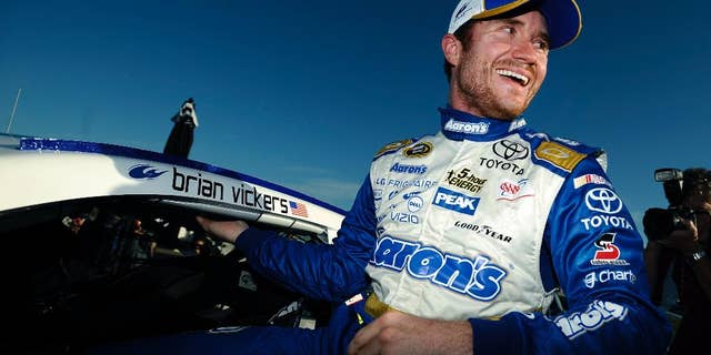 Brian Vickers climbs out of his car after winning the pole for Sunday's NASCAR Sprint Cup Series auto race at Talladega Superspeedway Saturday, Oct. 18, 2014, in Talladega, Ala. (AP Photo/Rainier Ehrhardt)