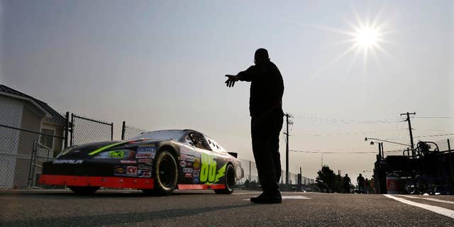 A race car heads out to the track during an early morning practice session for a NASCAR K&N Pro Series auto race at Watkins Glen International, Friday, Aug. 8, 2014, in Watkins Glen N.Y. (AP Photo/Mel Evans)