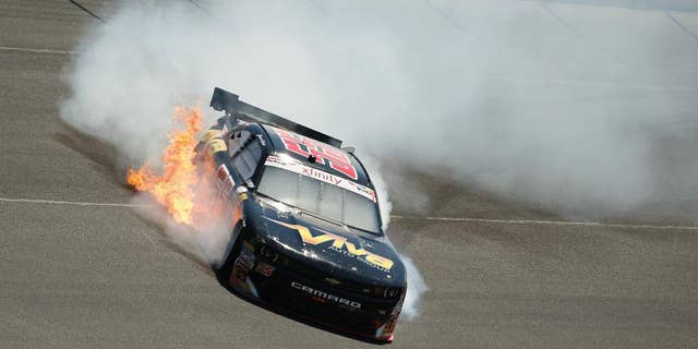 Flames shoot from Jamie Dick's car after he hit the wall during the NASCAR Xfinity series auto race at Charlotte Motor Speedway in Concord, N.C., on Saturday, May 23, 2015. (AP Photo/Chris Keane)