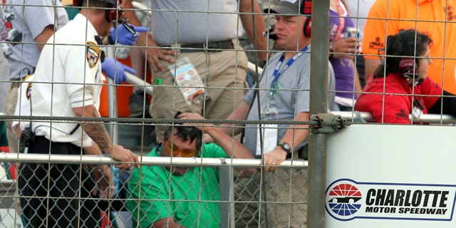 May 26, 2013: Security personnel assist a fan injured by a broken television camera cable during the NASCAR Sprint Cup series Coca-Cola 600 auto race at Charlotte Motor Speedway in Concord, N.C.
