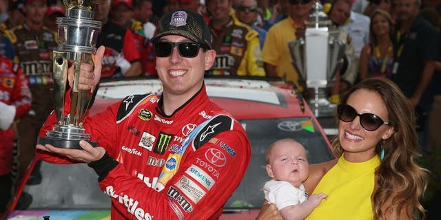 INDIANAPOLIS, IN - JULY 26: Kyle Busch, driver of the #18 Skittles Toyota, poses with the trophy in Victory Lane with wife Samantha and son Brexton Locke after winning the NASCAR Sprint Cup Series Crown Royal Presents the Jeff Kyle 400 at the Brickyard at Indianapolis Motor Speedway on July 26, 2015 in Indianapolis, Indiana. (Photo by Sean Gardner/NASCAR via Getty Images)