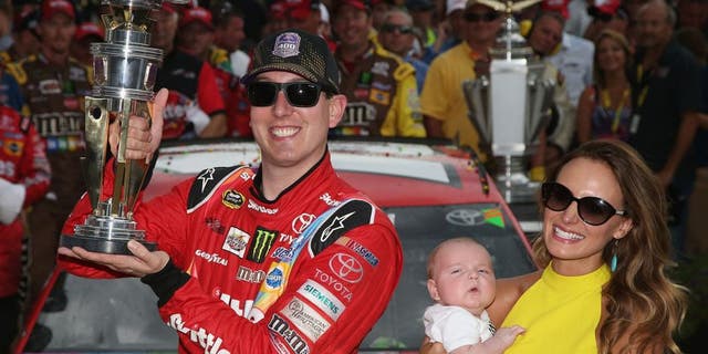 INDIANAPOLIS, IN - JULY 26: Kyle Busch, driver of the #18 Skittles Toyota, poses with the trophy in Victory Lane with wife Samantha and son Brexton Locke after winning the NASCAR Sprint Cup Series Crown Royal Presents the Jeff Kyle 400 at the Brickyard at Indianapolis Motor Speedway on July 26, 2015 in Indianapolis, Indiana. (Photo by Sean Gardner/NASCAR via Getty Images)
