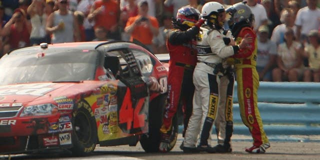 WATKINS GLEN, NY - AUGUST 12: Kevin Harvick, driver of the #29 Shell/Pennzoil Chevrolet, and Juan Pablo Montoya, driver of the #42 Wrigley's Big Red Dodge, are separated by NASCAR officials after the two collided during the NASCAR Nextel Cup Series Centurion Boats at The Glen at Watkins Glen International on August 12, 2007 in Watkins Glen, New York. (Photo by Chris McGrath/Getty Images) *** Local Caption *** Juan Pablo Montoya;Kevin Harvick
