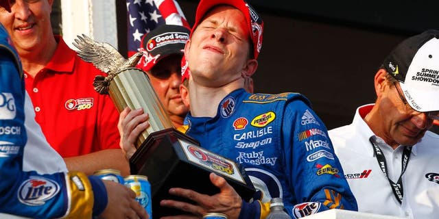 5-7 August, 2011, Long Pond, Pennsylvania USA Brad Keselowski winces in pain lifting the trophy (c)2011, Dan Streck LAT Photo USA