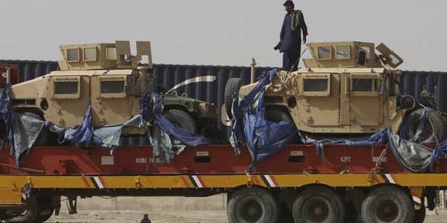 July 4, 2012: A driver stands on top of a truck carrying NATO Humvees at a terminal in the Pakistani-Afghan border, in Chaman, Pakistan.