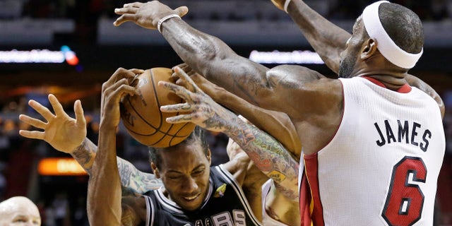 The Miami Heat's LeBron James (6) and Chris Andersen (11) defend San Antonio Spurs small forward Kawhi Leonard (2) during the first half of Game 2 of the NBA Finals basketball game, Sunday, June 9, 2013 in Miami. (AP Photo/Lynne Sladky)