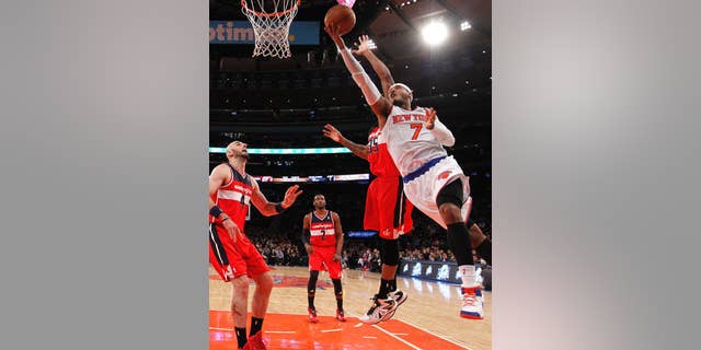 FILe - In this Dec. 16, 2013 file photo, New York Knicks' Carmelo Anthony (7) goes to the basket against Washington Wizards' Trevor Booker (35) during the first half of an NBA basketball game in New York. Signing day has arrived in the NBA, if the biggest free agents care to grab their pens. But it’s unclear if Carmelo Anthony, Chris Bosh and Dwyane Wade _ who all might be waiting on LeBron James to go first _ are ready.(AP Photo/Jason DeCrow, File)