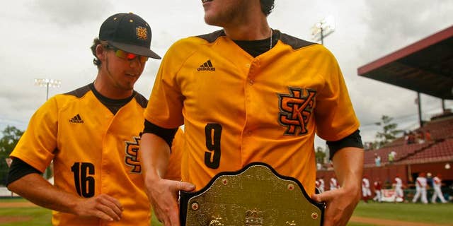 Kennesaw State's Will Lowman (16) helps winning pitcher Travis Bergen (9) adjust his championship belt after an NCAA college baseball tournament regional game against Alabama on Friday, May 30, 2014 in Tallahassee, Fla. Kennesaw State awards the belt to the player of the game when they win. Kennesaw State won 1-0. (AP Photo/Phil Sears)