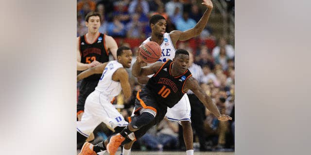 Mercer guard Ike Nwamu (10) moves the ball against Duke forward Amile Jefferson (21) during the second half of an NCAA college basketball second-round game, Friday, March 21, 2014, in Raleigh, N.C. (AP Photo/Chuck Burton)