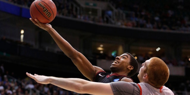 Harvard guard Wesley Saunders (23) takes a shot while defended by New Mexico center Alex Kirk (53) during the second half of their second round NCAA tournament basketball game in Salt Lake City, Utah.