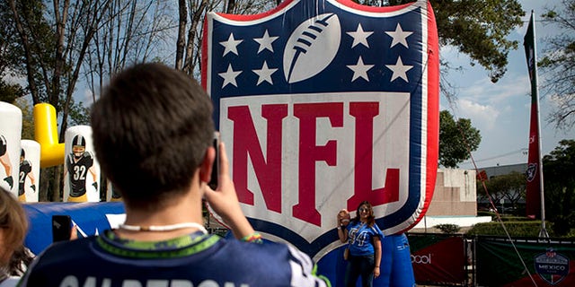 Fans take photos by the NFL logo set up at the third annual American Football Expo in Mexico City.