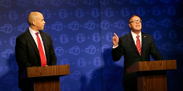 Oct. 4, 2013: Cory Booker (l.) looks on as Republican Steve Lonegan answers a question during their first debate of the U.S. Senate campaign in Trenton, N.J. Booker is Newark's two-term mayor. Lonegan is the former state director of a conservative advocacy group, Americans for Prosperity, and former mayor of Bogota, N.J.